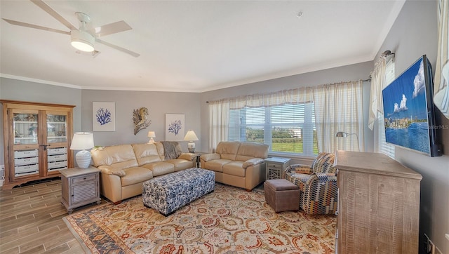 living area featuring a ceiling fan, ornamental molding, and wood tiled floor