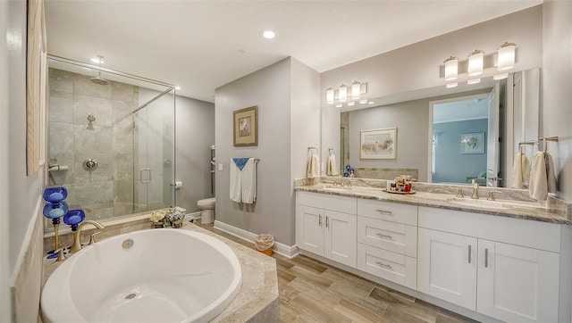 full bathroom with a garden tub, toilet, a sink, a shower stall, and double vanity