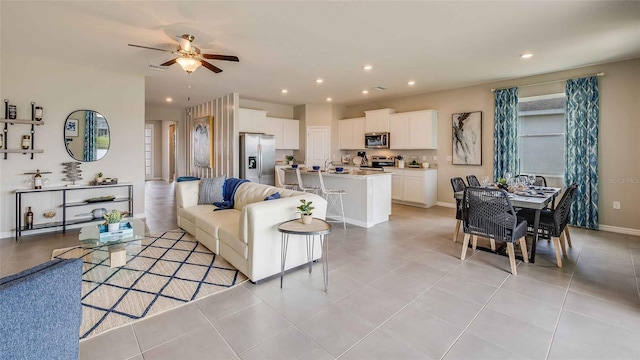 living area with light tile patterned floors, recessed lighting, baseboards, and ceiling fan