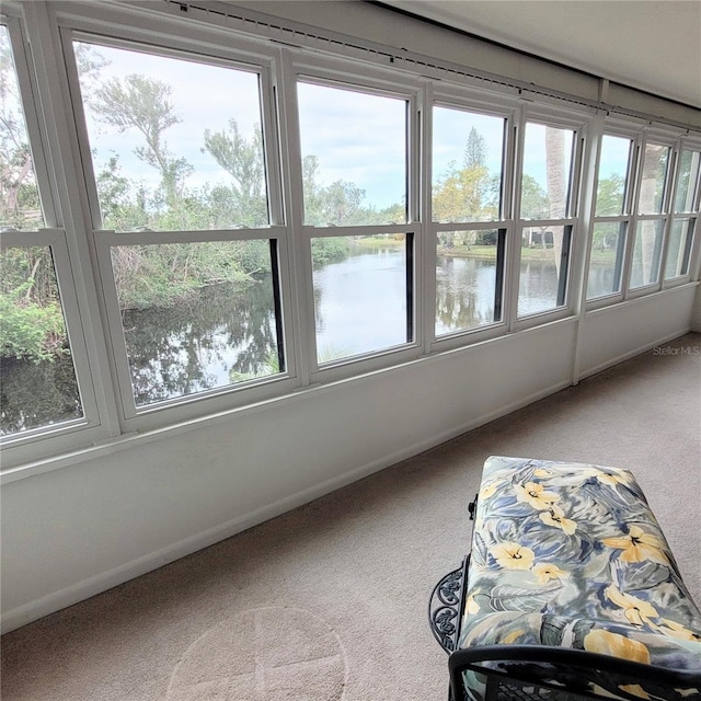 sunroom featuring a water view