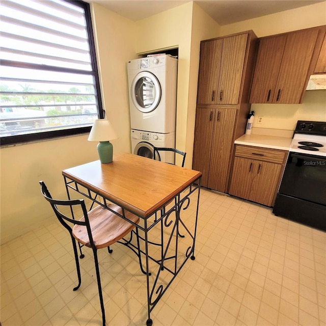 dining space with light floors and stacked washer and clothes dryer