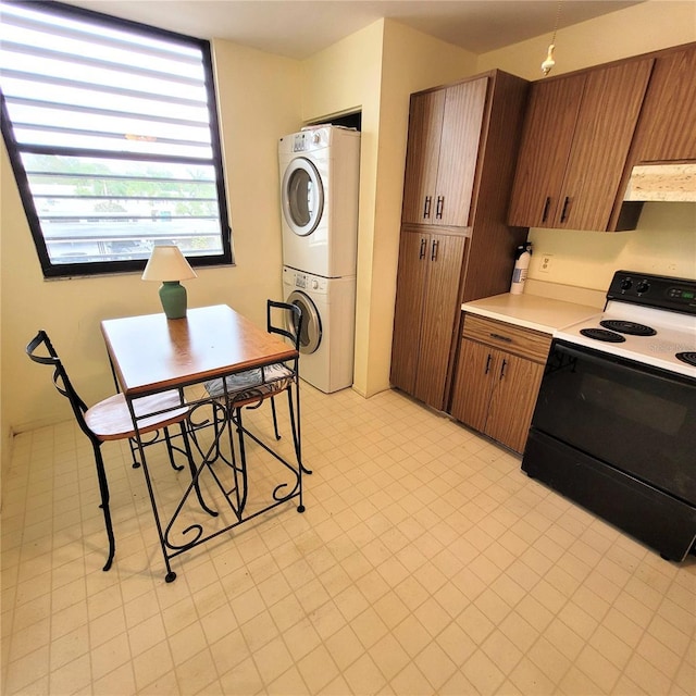 kitchen with light floors, stacked washing maching and dryer, electric range, light countertops, and under cabinet range hood