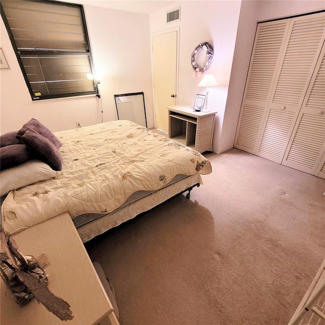 carpeted bedroom with a closet and visible vents