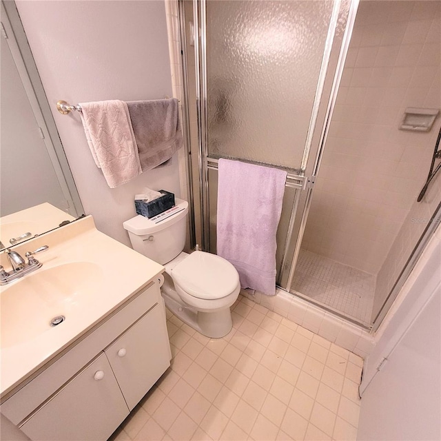 bathroom featuring a shower stall, toilet, and vanity