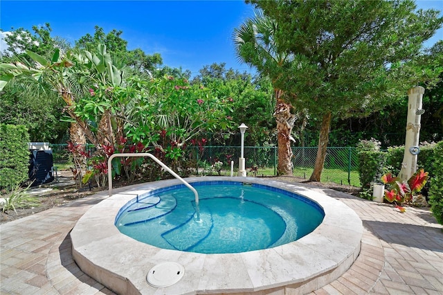 view of pool featuring a community hot tub and fence