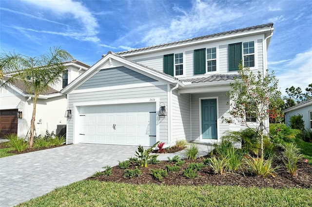 traditional-style house with a garage and decorative driveway