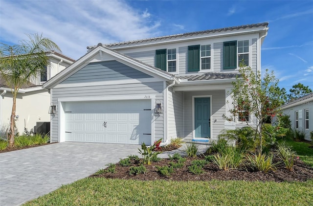 traditional-style house with an attached garage and decorative driveway