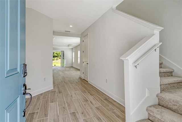 entrance foyer featuring visible vents, baseboards, light wood-style flooring, recessed lighting, and stairs