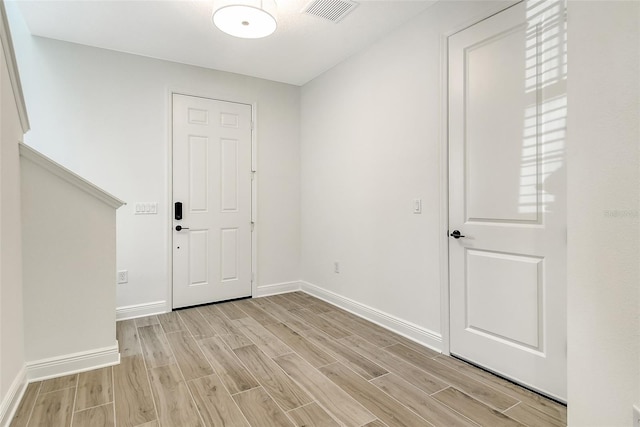 entrance foyer with baseboards, visible vents, and wood finish floors