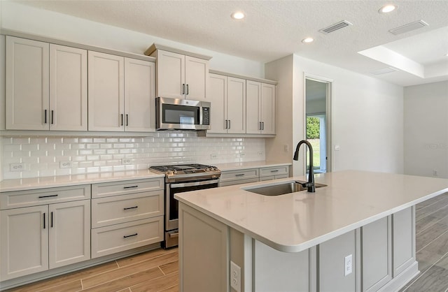 kitchen featuring a sink, visible vents, appliances with stainless steel finishes, and wood tiled floor