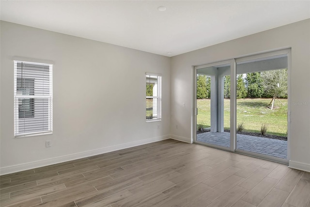 empty room featuring baseboards and wood finished floors