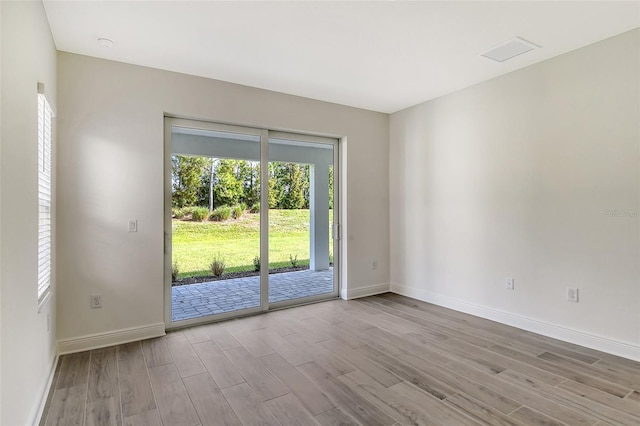 unfurnished room with baseboards and wood finished floors