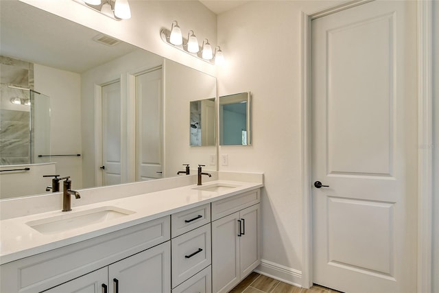 bathroom featuring double vanity, baseboards, visible vents, and a sink