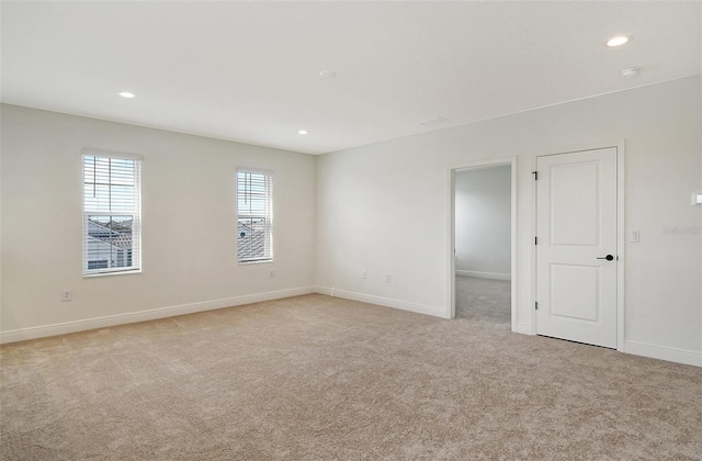 unfurnished room with recessed lighting, baseboards, and light carpet