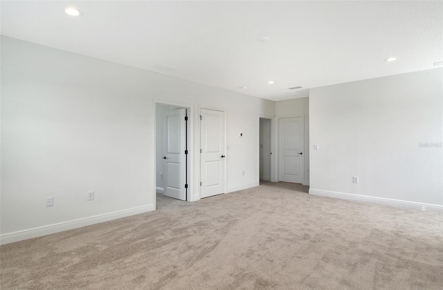 unfurnished bedroom featuring visible vents, recessed lighting, baseboards, and light carpet