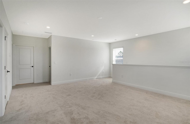 unfurnished room with recessed lighting, baseboards, and light carpet