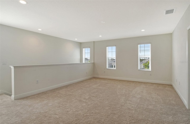 empty room featuring recessed lighting, baseboards, light carpet, and visible vents