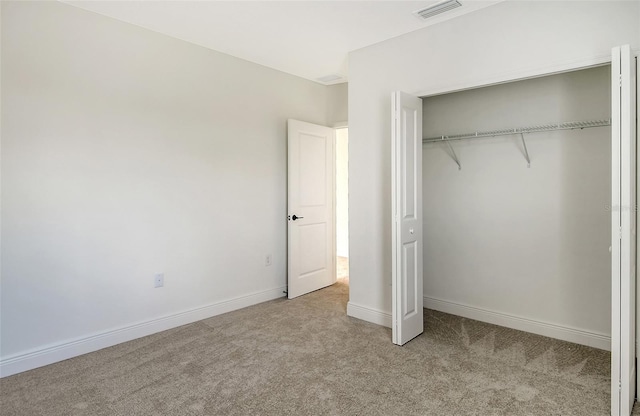 unfurnished bedroom with visible vents, baseboards, a closet, and carpet flooring