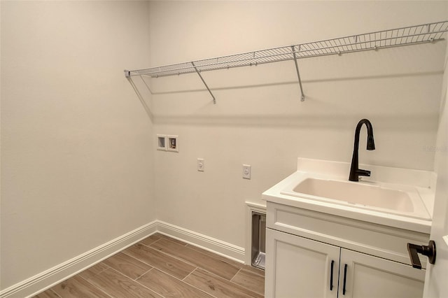 clothes washing area featuring hookup for a washing machine, baseboards, wood tiled floor, electric dryer hookup, and a sink