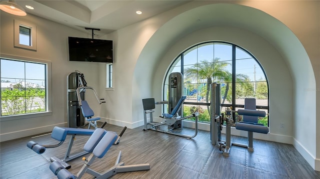 exercise area featuring vaulted ceiling, plenty of natural light, recessed lighting, and baseboards