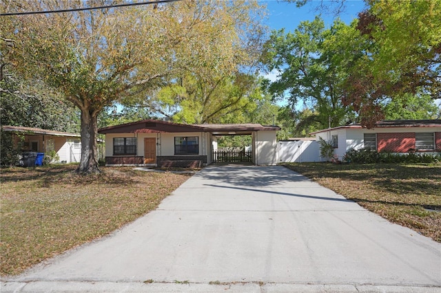 124 E 119th Ave, Tampa, FL 33612 - view of front of property with a gate, fence, a front yard, an attached carport, and driveway