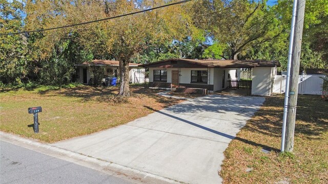124 E 119th Ave, Tampa, FL 33612 - ranch-style home featuring an attached carport, fence, concrete driveway, and a front yard
