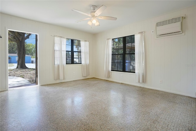 124 E 119th Ave, Tampa, FL 33612 - spare room featuring baseboards, speckled floor, a wall unit AC, and a ceiling fan