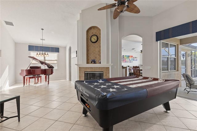 recreation room featuring visible vents, light tile patterned flooring, a fireplace, arched walkways, and ceiling fan
