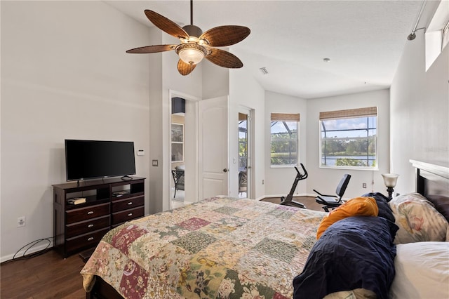 bedroom featuring dark wood-type flooring, a ceiling fan, baseboards, and vaulted ceiling