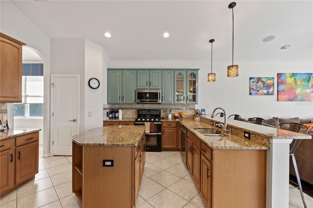 kitchen with decorative backsplash, a peninsula, a kitchen breakfast bar, stainless steel appliances, and a sink