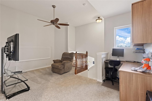 carpeted office space featuring baseboards and ceiling fan