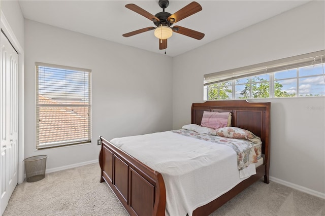 bedroom with baseboards, a closet, and light carpet