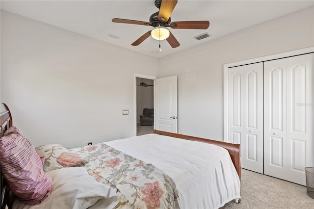 bedroom featuring visible vents, light colored carpet, a closet, and ceiling fan