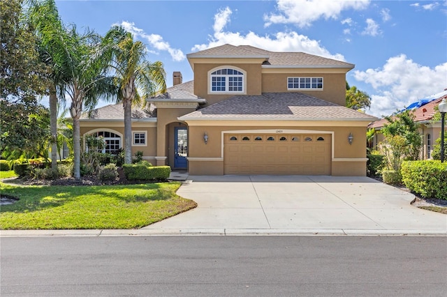 mediterranean / spanish-style house with a front lawn, stucco siding, a chimney, a garage, and driveway