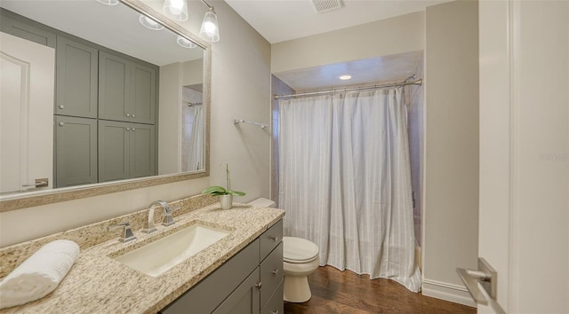 full bath with visible vents, toilet, wood finished floors, shower / bath combination with curtain, and vanity