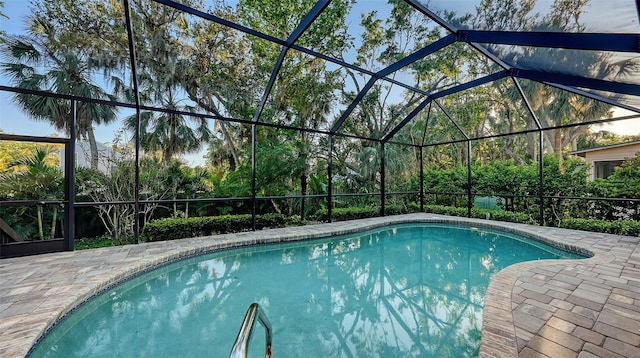 pool with glass enclosure and a patio area