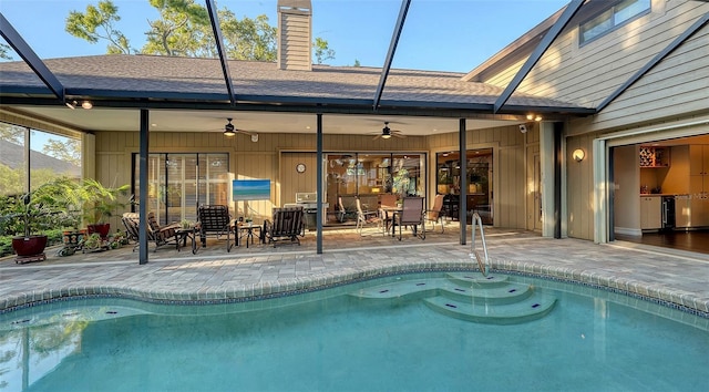 outdoor pool with glass enclosure, a patio area, and ceiling fan