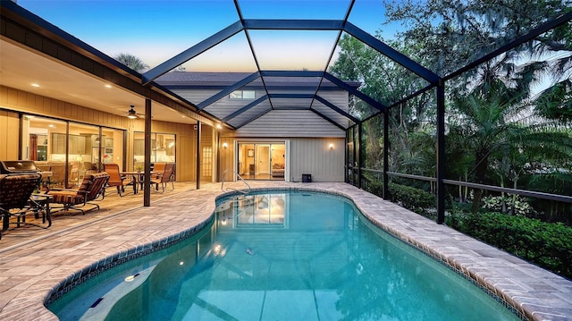 pool with glass enclosure and a patio area