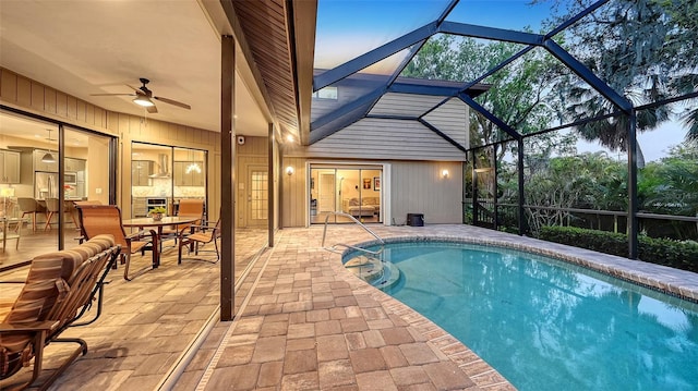 outdoor pool with a patio area, a lanai, and ceiling fan