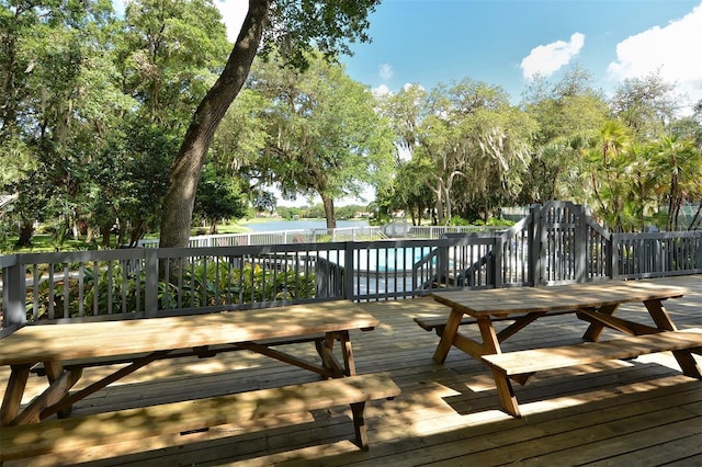 wooden deck featuring a swimming pool and fence