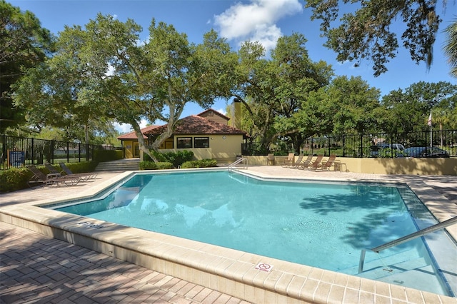 community pool featuring a patio area and fence