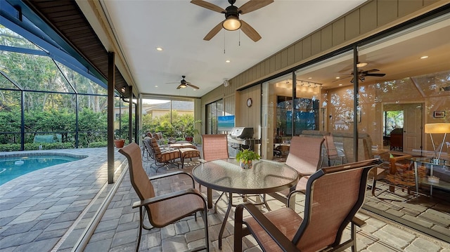 view of patio with glass enclosure, outdoor dining area, an outdoor pool, and ceiling fan