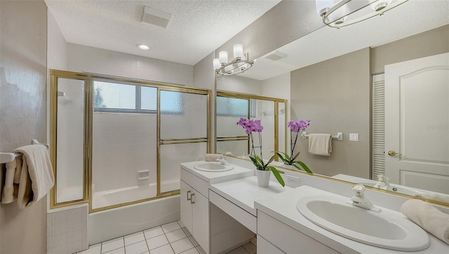 bathroom featuring tile patterned flooring, a textured ceiling, double vanity, and a sink