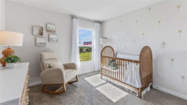 bedroom with a nursery area, baseboards, and carpet floors