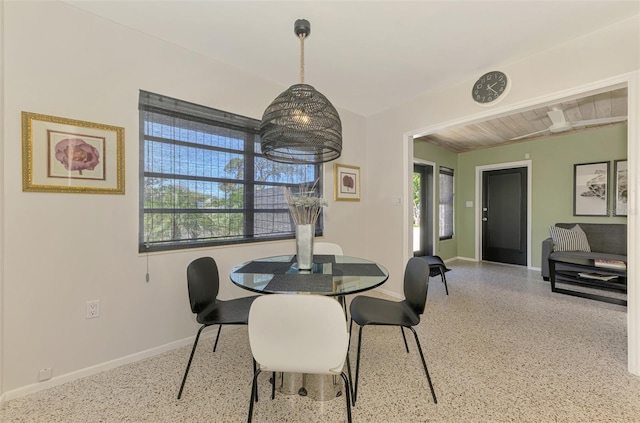 dining room featuring speckled floor and baseboards