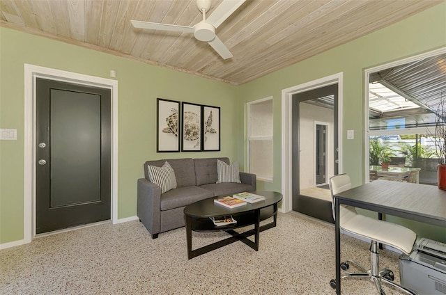 living area with baseboards, wood ceiling, and a ceiling fan