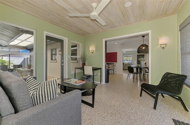 living area with wood ceiling, light speckled floor, a ceiling fan, and a wealth of natural light