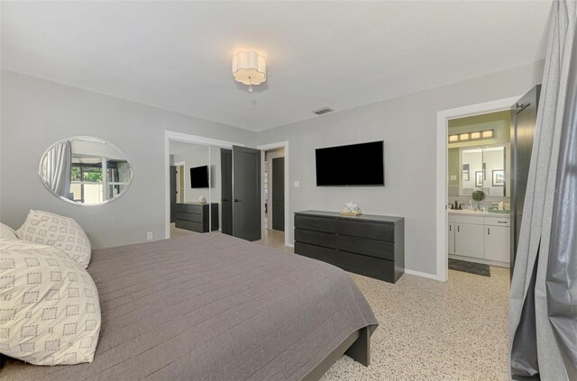 bedroom with connected bathroom, baseboards, and visible vents