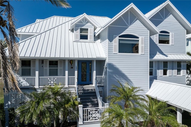 137 Big Pass Ln, Sarasota, FL 34242 - view of front facade with metal roof, covered porch, a standing seam roof, and stairway