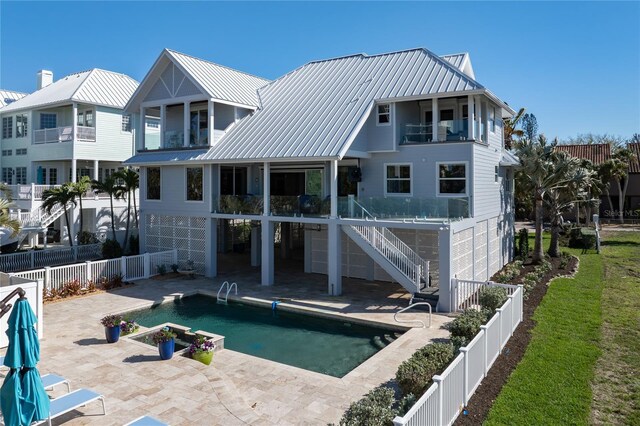 137 Big Pass Ln, Sarasota, FL 34242 - rear view of property with stairs, metal roof, a fenced backyard, a balcony, and a patio area